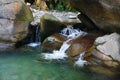 Small beautiful waterfall among the rocks of mountain creek Royalty Free Stock Photo