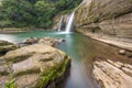 Small but beautiful waterfalls, clear streams, big rocks and green trees.