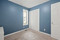 Small bedroom with a blue wall and white door Royalty Free Stock Photo