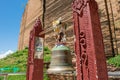 A small bell hanging on to an iron bar supported by two columns, next to Mingun Pahtodawgyi Pagoda