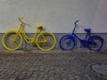 Yellow and blue bike leaned againist the wall