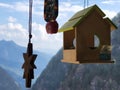 Small bird house and bell with windchime with a background of hilly areas of Himalayas