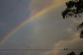 Small birds on lines of electric power. Great storm behind and a rainbow Royalty Free Stock Photo