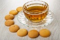 Small biscuits around cup with tea on wooden table Royalty Free Stock Photo