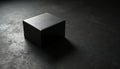 Small black box sits on dark grey concrete background. Single light illuminates mystery object, casting subtle shadow. Simple Royalty Free Stock Photo