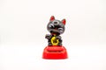 Small black cat next to Chinese scroll figurine Royalty Free Stock Photo
