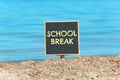 Small black chalkboard with text School Break on beach. Seasonal holidays Royalty Free Stock Photo