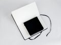 Small black closed notepad and large open notebook with blank white pages and ribbon bookmark lie unfold. Top view