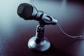 Small black desk microphone with cable and low stand on a black table. Modern style, Communication concept Royalty Free Stock Photo