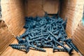 Small black wood screws close-up in a cardboard box Royalty Free Stock Photo