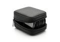Small black zippered case holding multiple circular objects isolated on white background Royalty Free Stock Photo