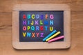 Small blackboard with color chalks and color English alphabets o Royalty Free Stock Photo