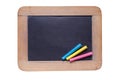 Small blackboard with color chalks on white background Royalty Free Stock Photo