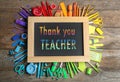 Small blackboard with phrase Thank You Teacher and different colorful stationery on wooden table, flat lay Royalty Free Stock Photo