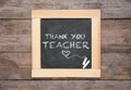 Small blackboard with pieces of chalk and phrase Thank you, teacher on wooden table, top view Royalty Free Stock Photo