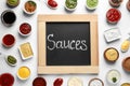 Small blackboard with word Sauces and different dressings on white background Royalty Free Stock Photo