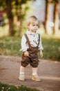 A small blond boy dressed in a vintage jumpsuit in a field at sunset Royalty Free Stock Photo