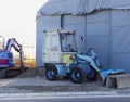 A small blue backhoe parked