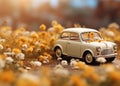 A small blue childrens car stands on an autumn yellow background and beautiful white daisies are on it