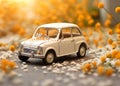 A small blue childrens car stands on an autumn yellow background and beautiful white daisies are on it