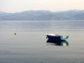 Small Blue Fishing Boat in Calm Sea Water Royalty Free Stock Photo