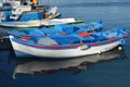 Small blue fishing boats with reflection on the water moored at the pier, Crete, Greece Royalty Free Stock Photo