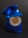 Small blue gift bag with ribbon and blank label