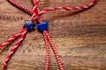 Small blue heart and star on red and white bakers twine with wooden background/International women`s day concept Royalty Free Stock Photo