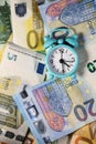 Small blue retro alarm clock on a euro banknotes background. Finance. Financial crisis. Banking system. Economic problem. Royalty Free Stock Photo