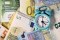 Small blue retro alarm clock on a euro banknotes background. Finance. Financial crisis. Banking system. Economic problem. Royalty Free Stock Photo