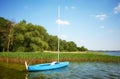 Small blue sailboat moored by reeds, Drawsko Lake, Poland