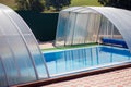 A small blue swimming pool with water under a canopy in the stre