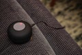 Small bluetooth speaker being charged on the couch close up view