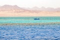 A small boat against the background of mountains and the sea in Ras Mohammed National Park, Egypt Royalty Free Stock Photo