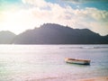 Small boat anchored off a Seychelles beach with light leak Royalty Free Stock Photo