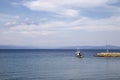 Small boat in blue sea approaching the harbor Royalty Free Stock Photo