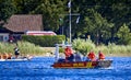 Small boat of the DLRG, the German lifesaving society, patrols a lake with two men and a woman