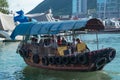 Small boat junk in Hong Kong taking tourists on harbor tours