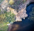 A small boat landed on the shore in the reeds of a small forest lake