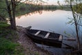 Small boat with oars near the riverbank at sunset. Royalty Free Stock Photo