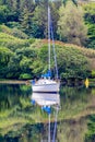 Small boat reflecting in the water, anchored in Clifden Bay at high tide