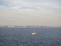 Small boat sailing on the open sea under the cloudy sky Royalty Free Stock Photo