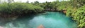 Small boat sailing in a picturesque lagoon surrounded by lush greenery in Cenote, Bermuda