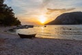 A small boat on the shore of the bay in the background of the sunset Royalty Free Stock Photo