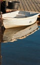 Small boat tied to a wooden dock and reflection Royalty Free Stock Photo