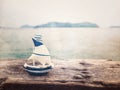 Small boat toy on wood plank over sea background with copy space Royalty Free Stock Photo