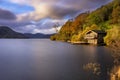 a small boathouse sits at the edge of a lake