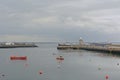 Small boats along a pier with lighthouse in the harbor of Howth