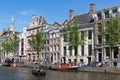 Small boats in canal with historic mansions in Amsterdam Royalty Free Stock Photo