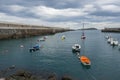 Small boats at the entrance of the fishing port of Bermeo on the coast of Vizcaya on a cloudy day